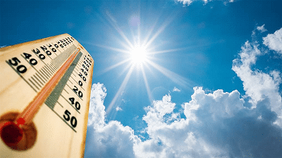 Bright sun shines against a blue sky with a thermometer in the foreground.