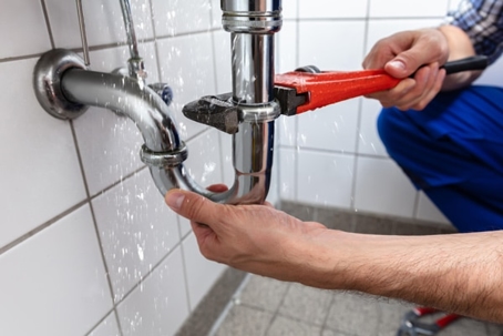 A plumber fixing a sink pipe